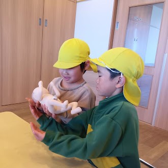 胎児人形を抱っこする子どもたち