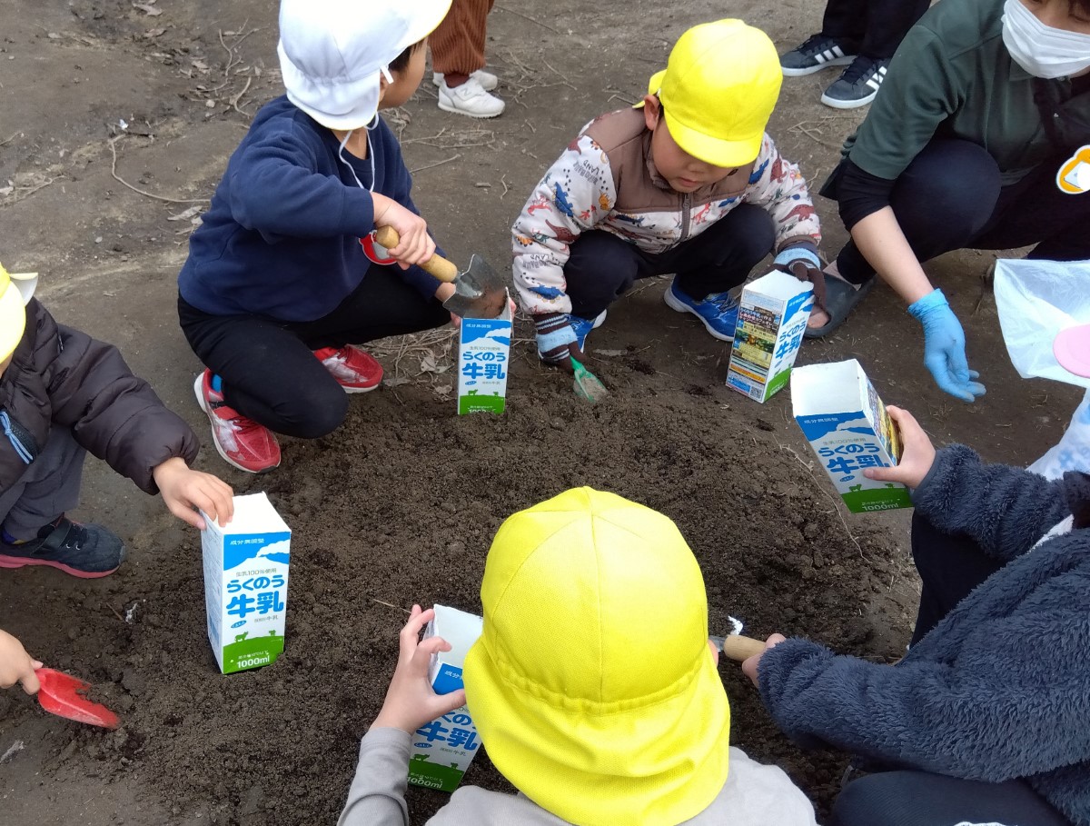 土を牛乳パックに入れる子どもたち