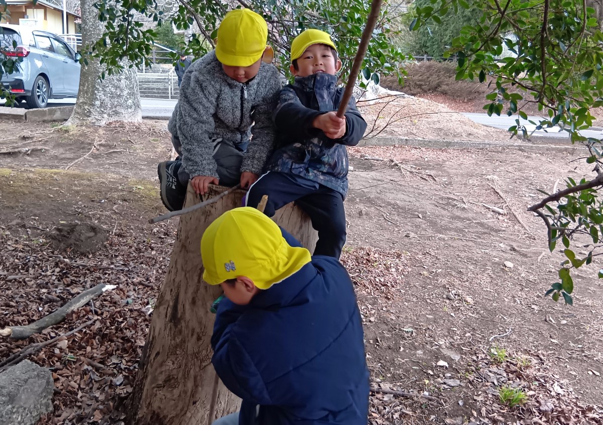 切り株に乗って遊ぶ子どもたち