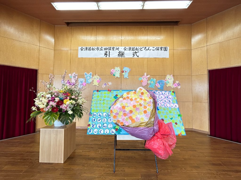 引継式で飾られた花束とメッセージパネル