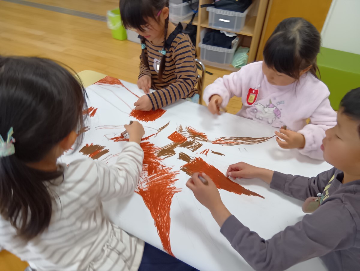 絵の具で大きな木を描く子どもたち