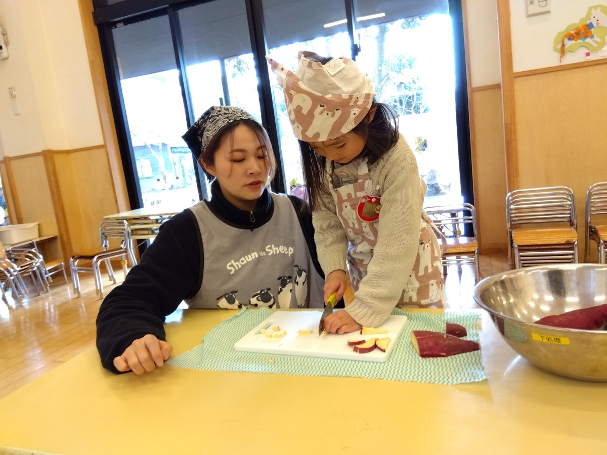 包丁を使ってサツマイモを切る子ども