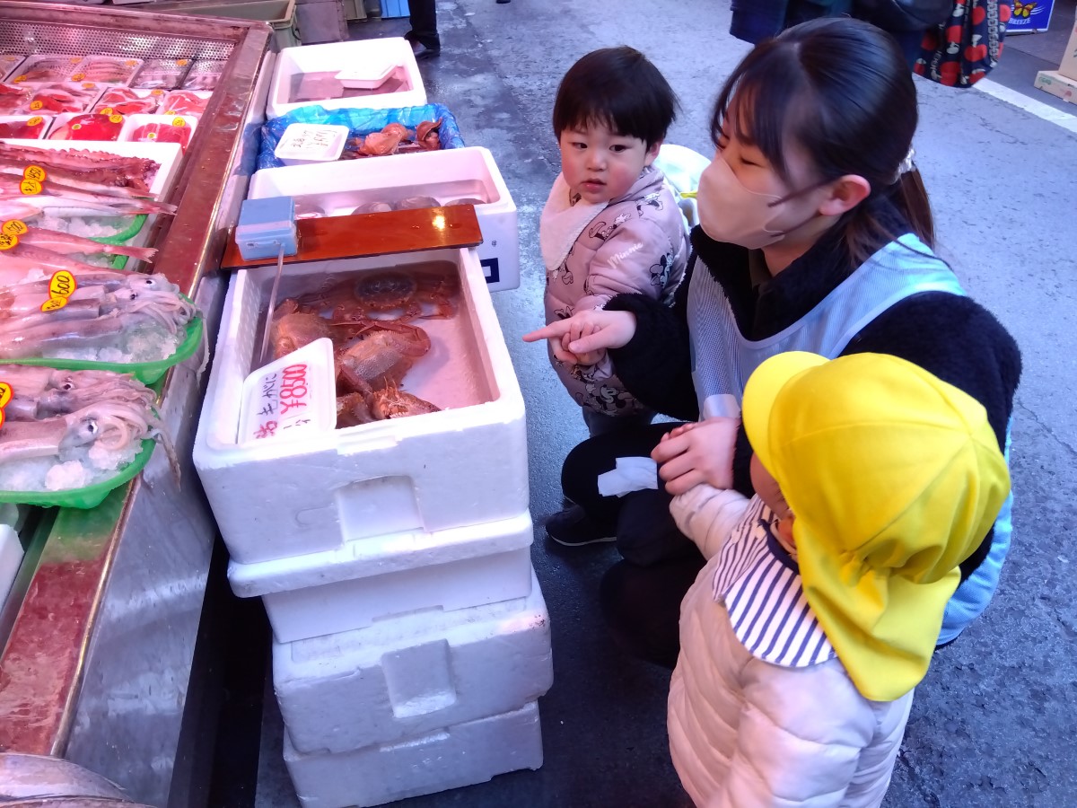 店にある毛ガニを眺める子どもたち