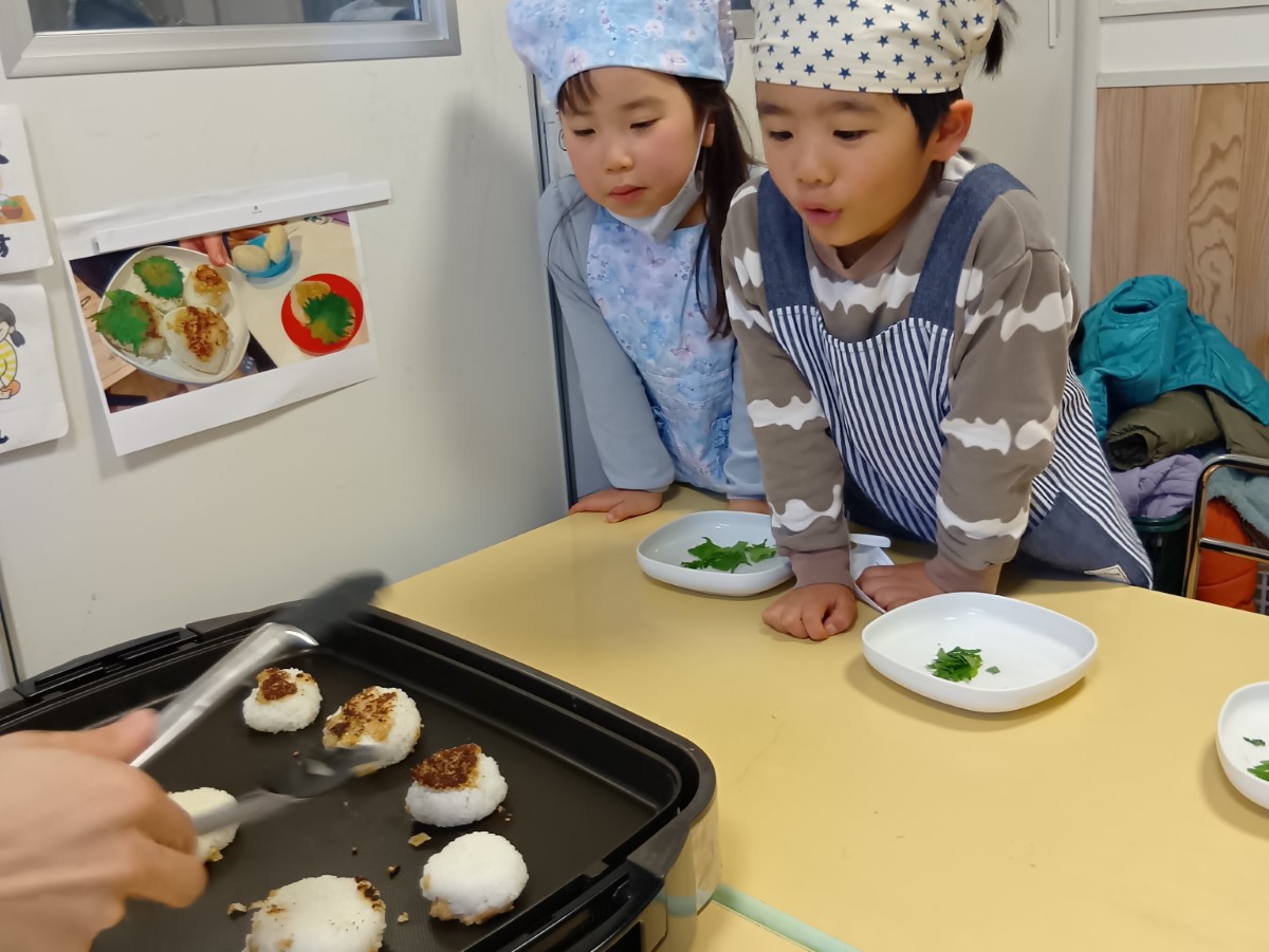 ホットプレートでおにぎりを焼く子どもたち