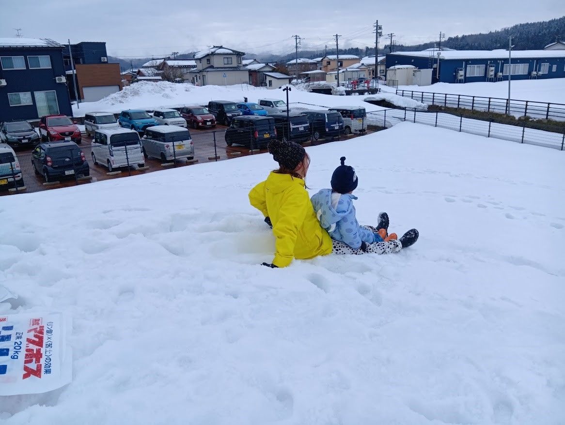 そり遊びをするスタッフと子ども