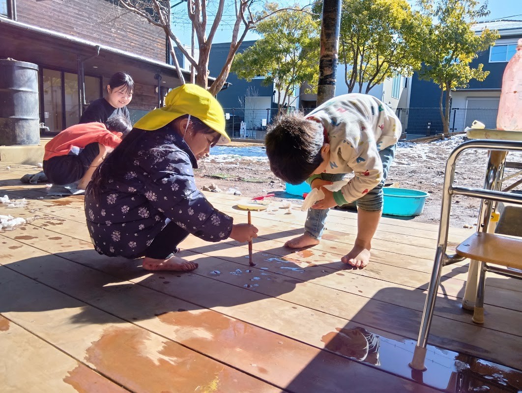 床を濡らして絵を描く子どもたち