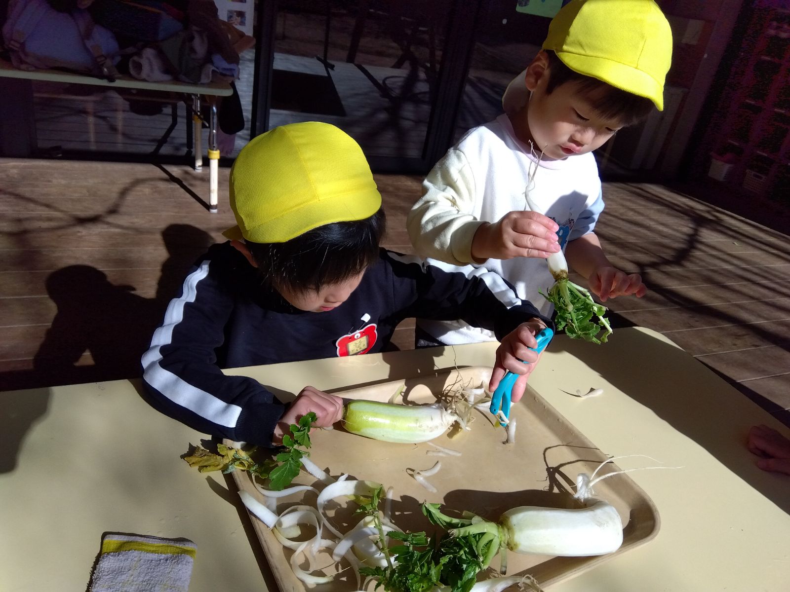 収穫した大根の皮をむく子どもたち