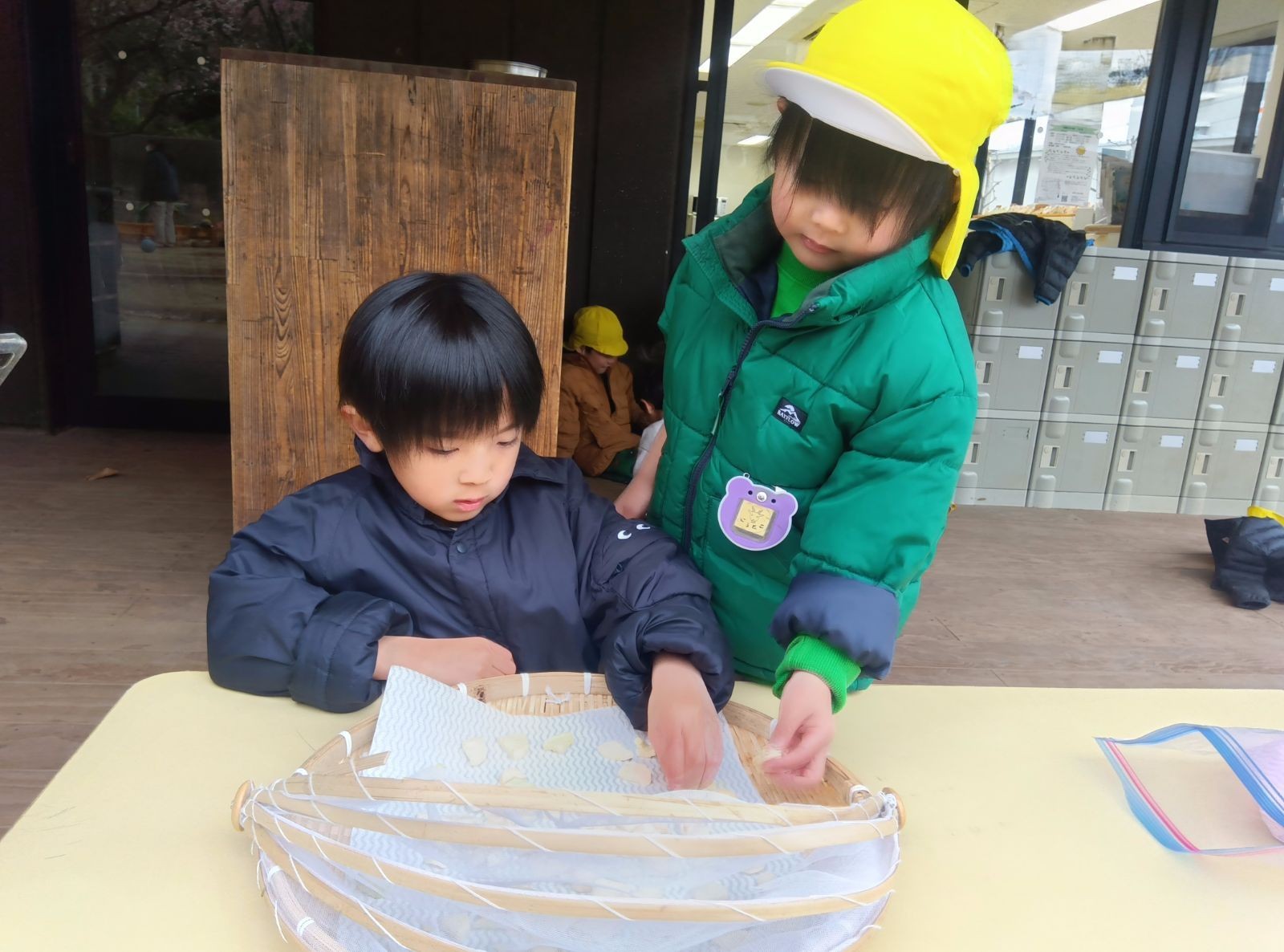 いちょう切りにした大根をザルの上に並べる子どもたち