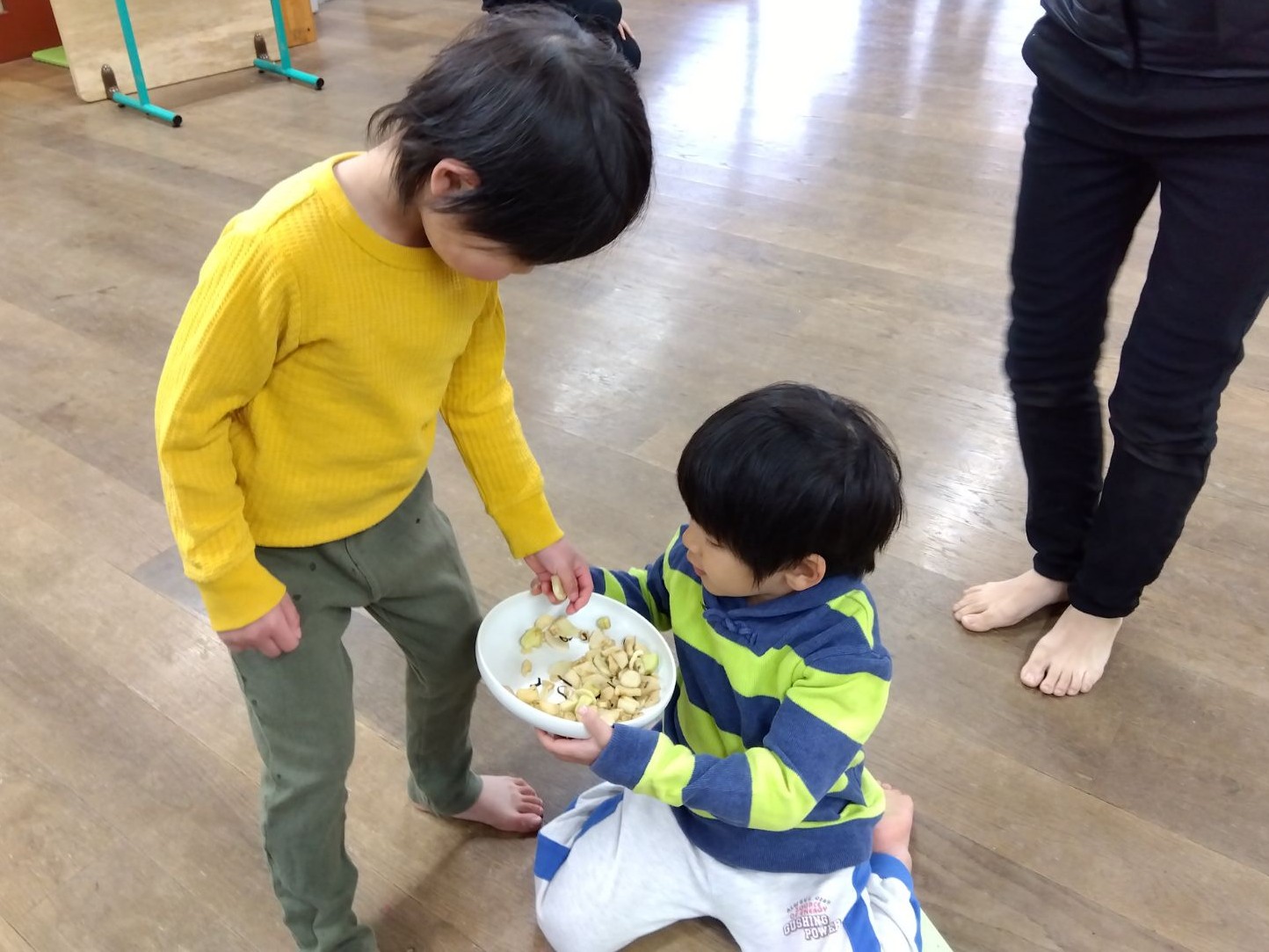 完成した切り干し大根の塩昆布漬けを配る子ども