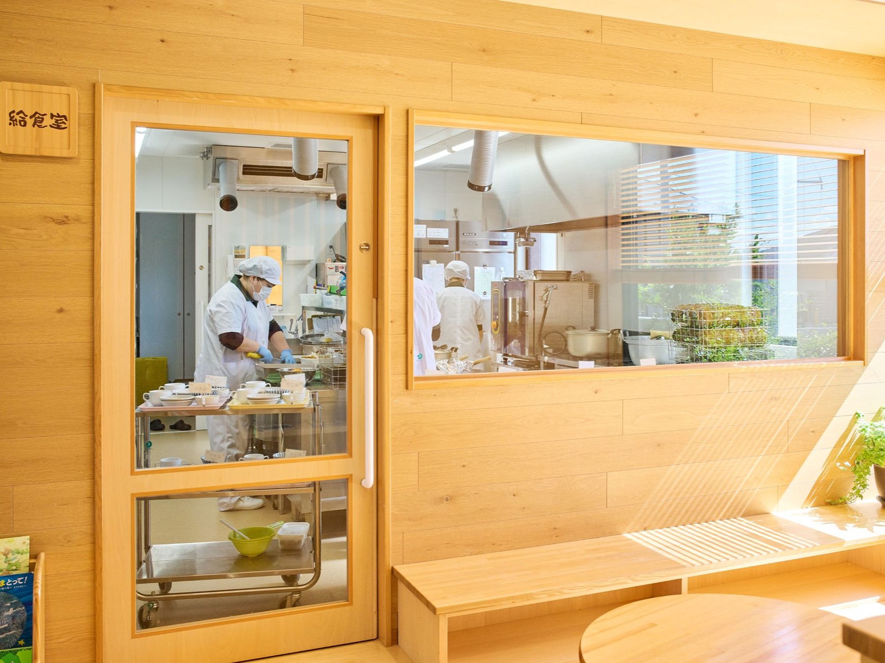 大きなガラス窓のある調理室を外から眺めた様子