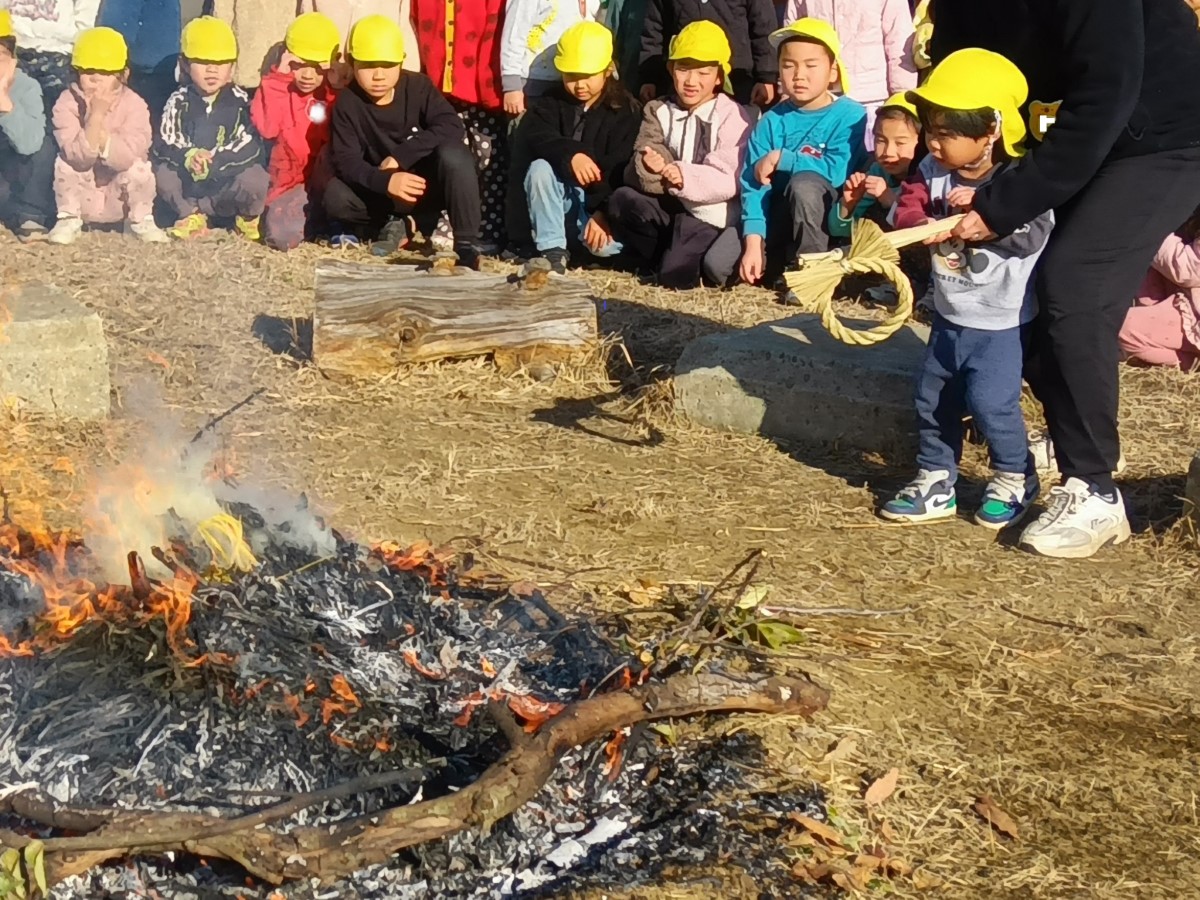 正月飾りを火の中に入れる子ども