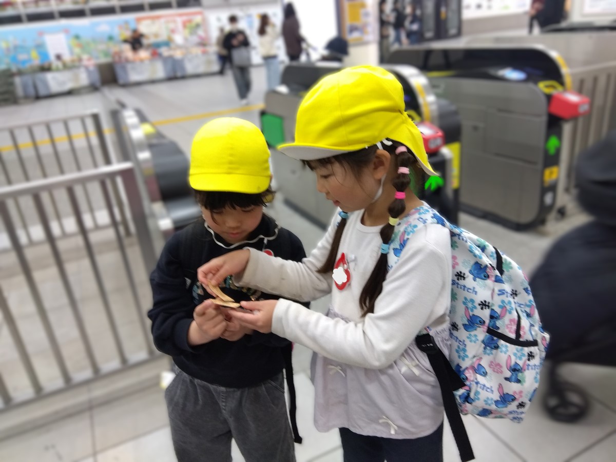 駅で切符を確認する子どもたち
