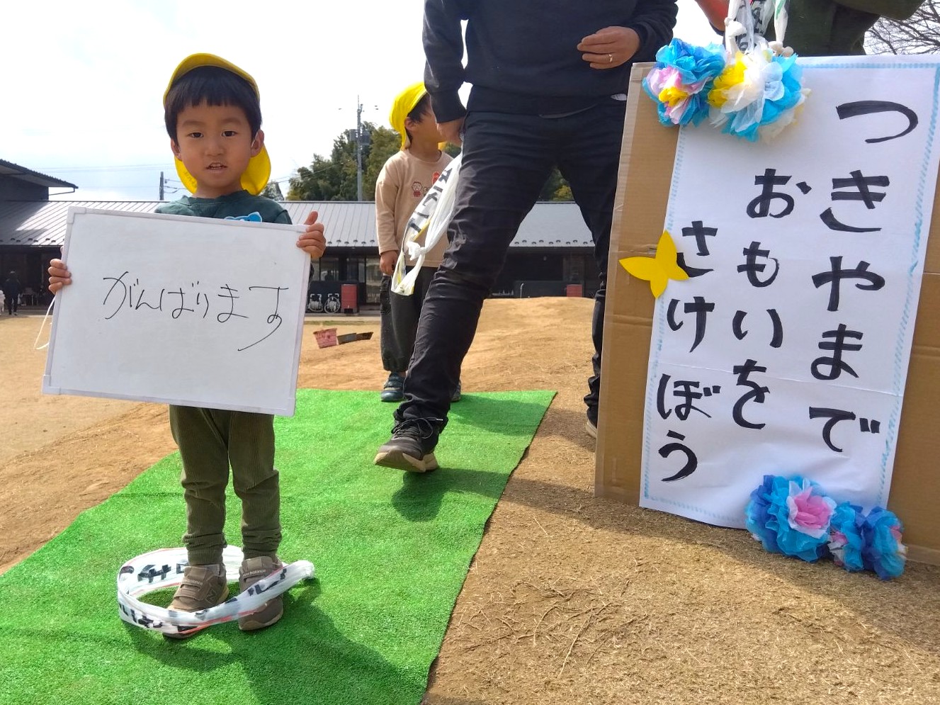 「がんばります」と書かれたボードをかかげる子ども