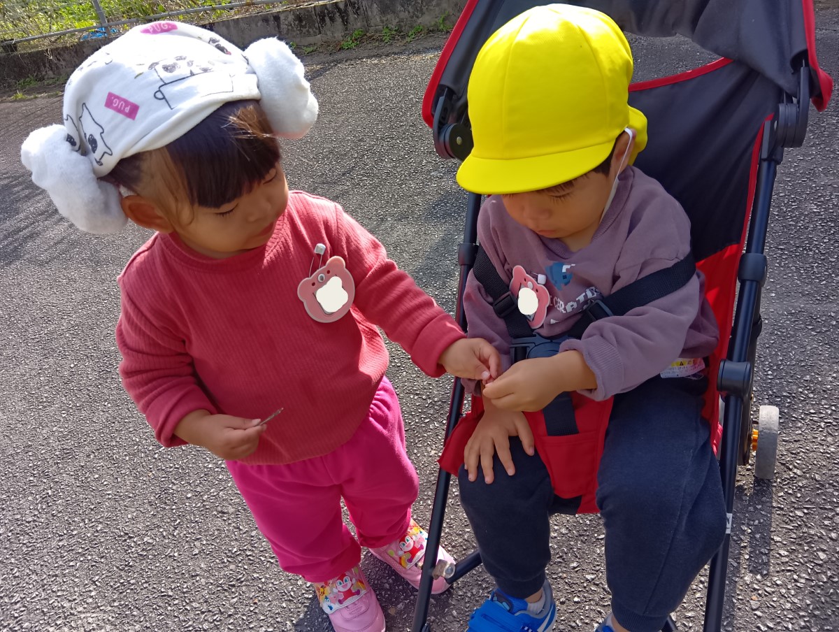 友達にどんぐりを渡す子どもの様子