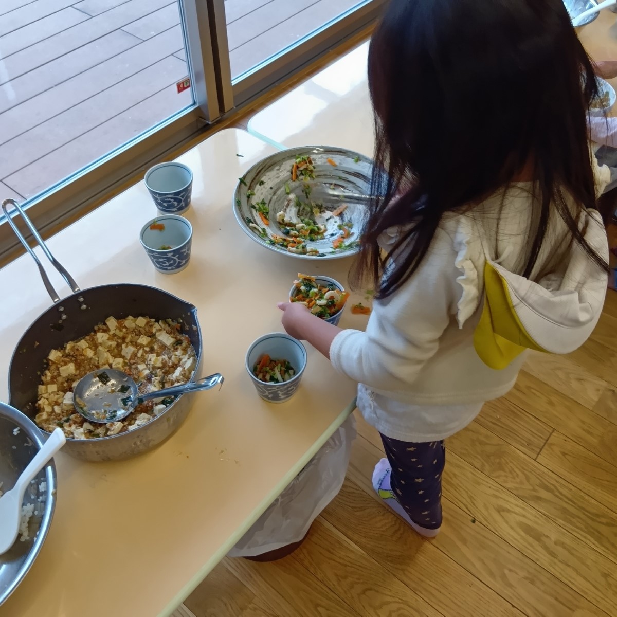 給食のおかずを取り分ける子ども