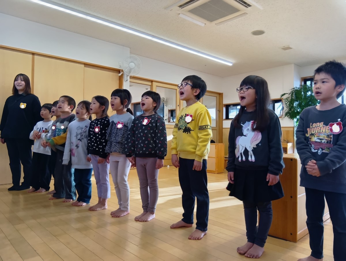 1列に並んで歌を歌う子どもたち
