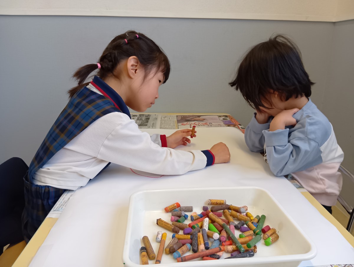 クレヨンで絵を描く子どもたち