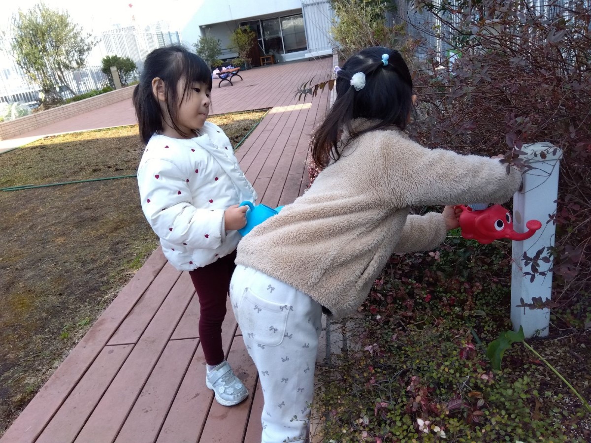 ジョウロに水を入れる子どもたち