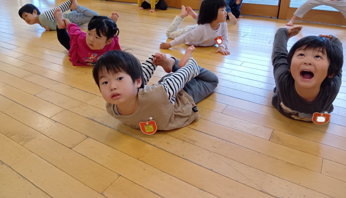 うつぶせになって上半身を上げる子どもたち