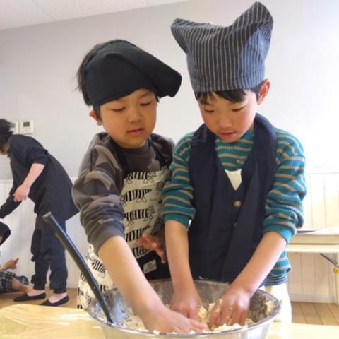 二人の子どもが一緒にスコーンの生地を混ぜている