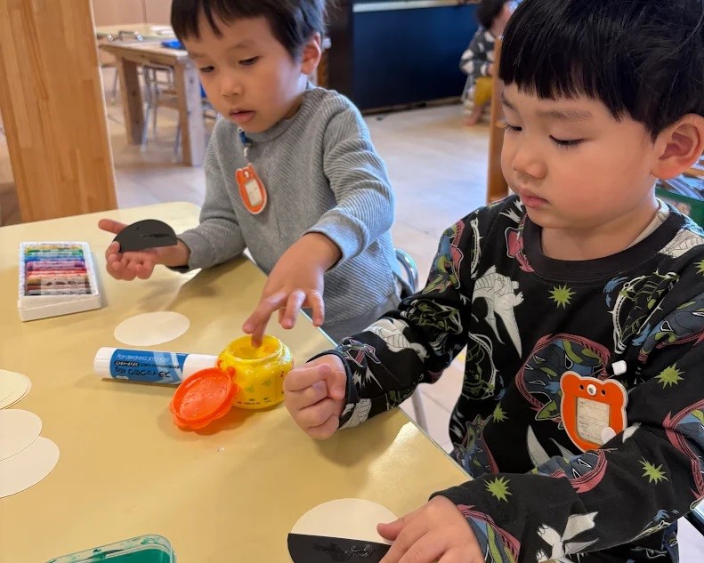 指でのりをすくう子どもたち