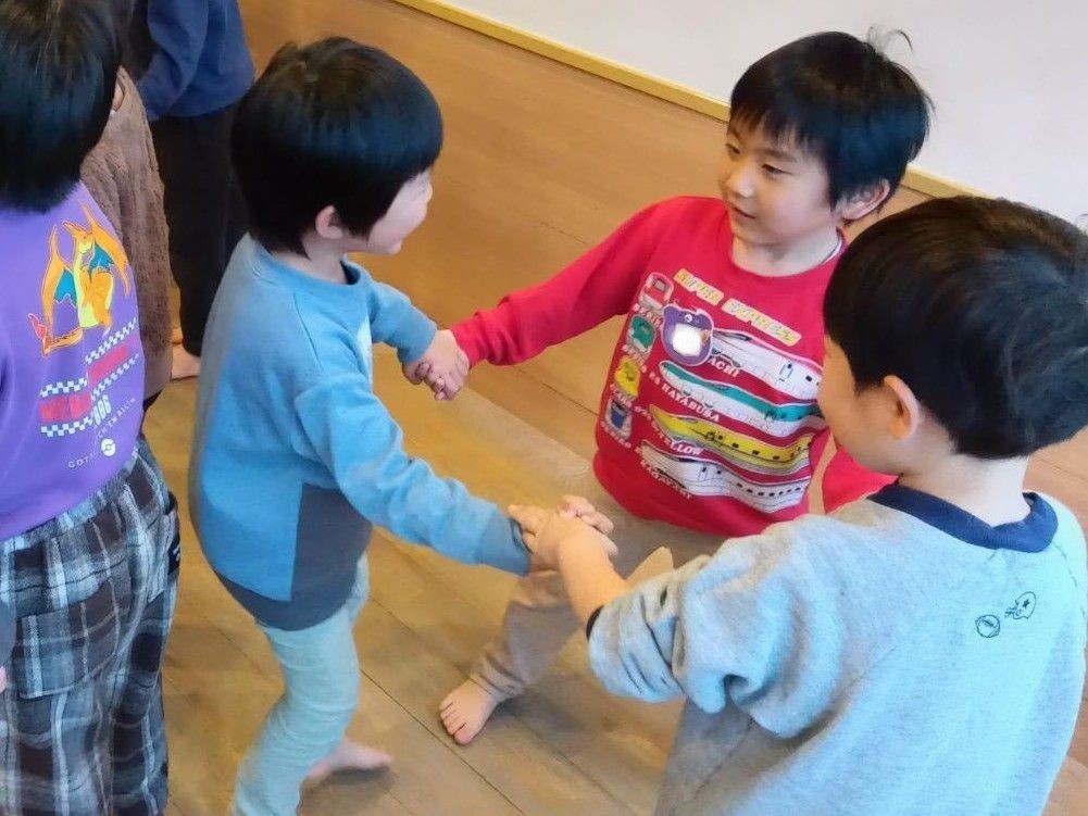 子どもたちが手をつないで輪になっているところ