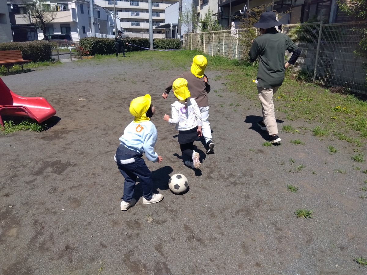 公園でサッカーボールを使って遊ぶ子どもたち