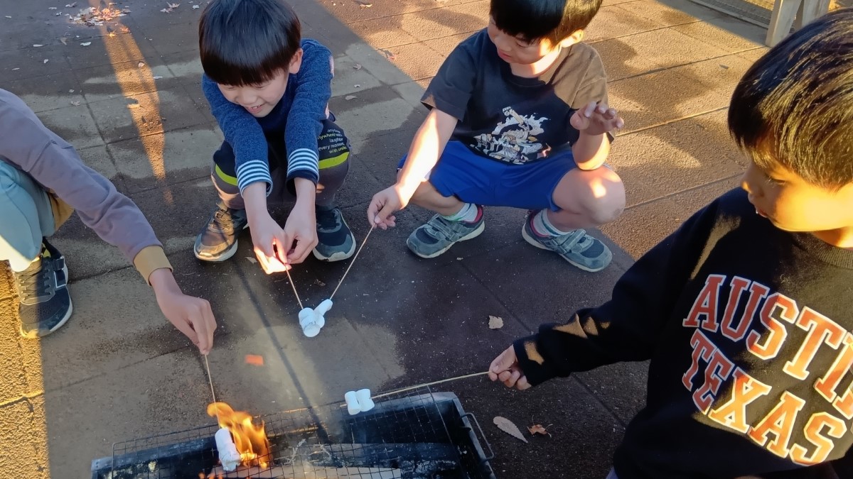 焚き火でマシュマロを焼く子どもたち