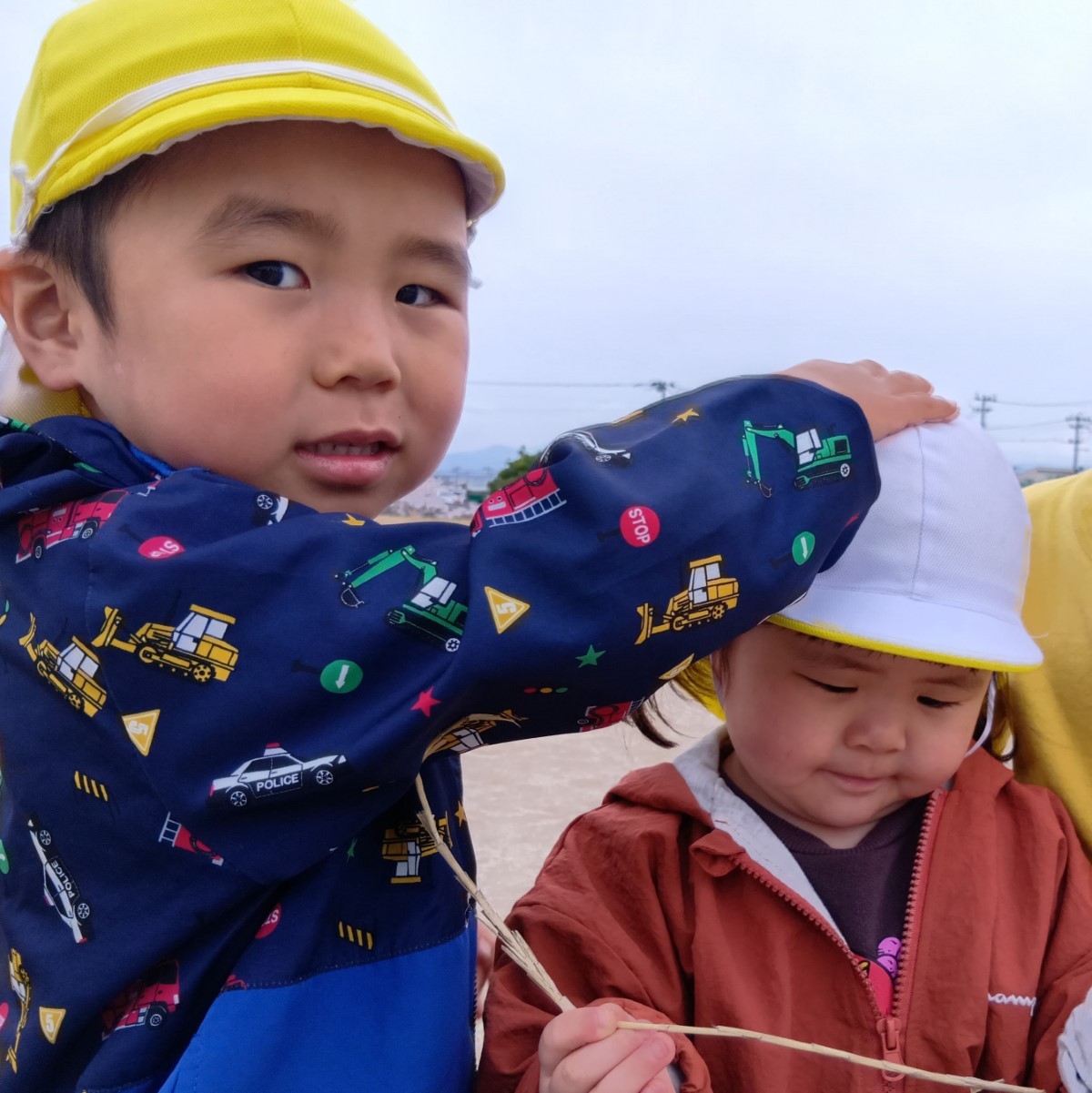 年上児の男の子が年下児の女の子の頭を優しくなでている