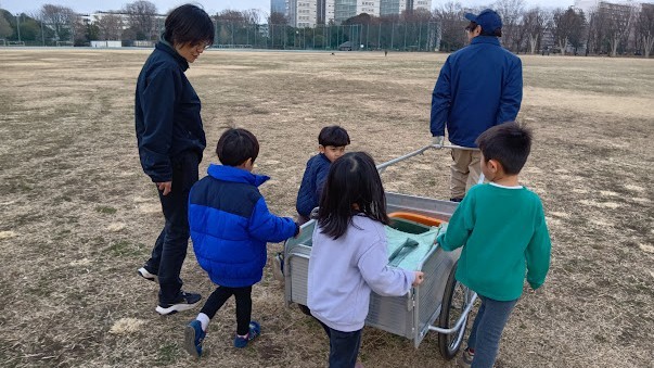 職員が台車を引き、子どもたちはその台車を押している