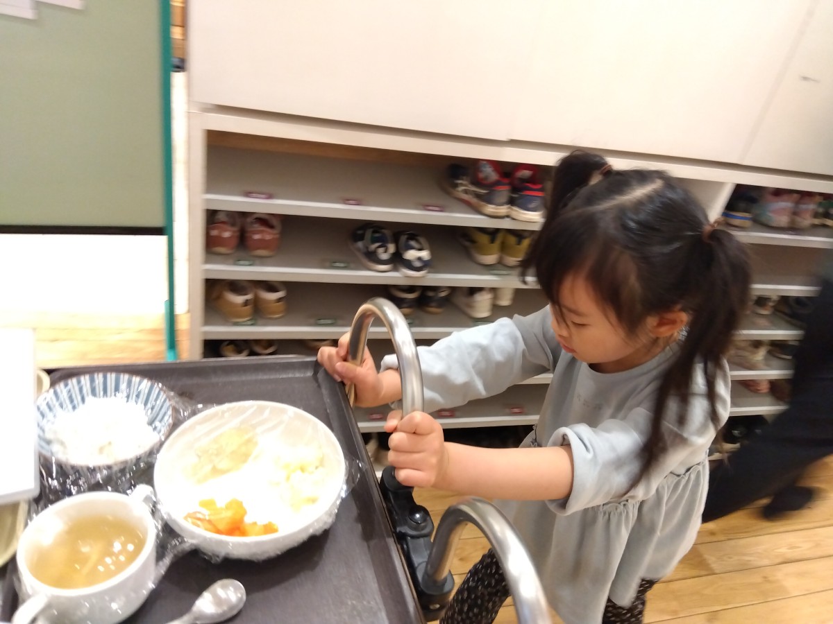 給食が乗ったワゴンを押す子ども