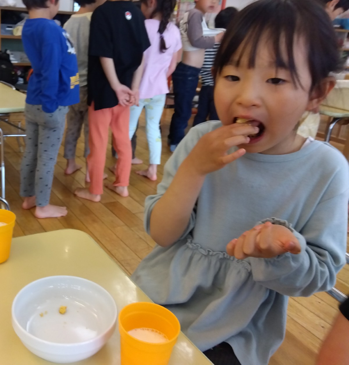 子どもが大きな口を開けて、おやつを食べている