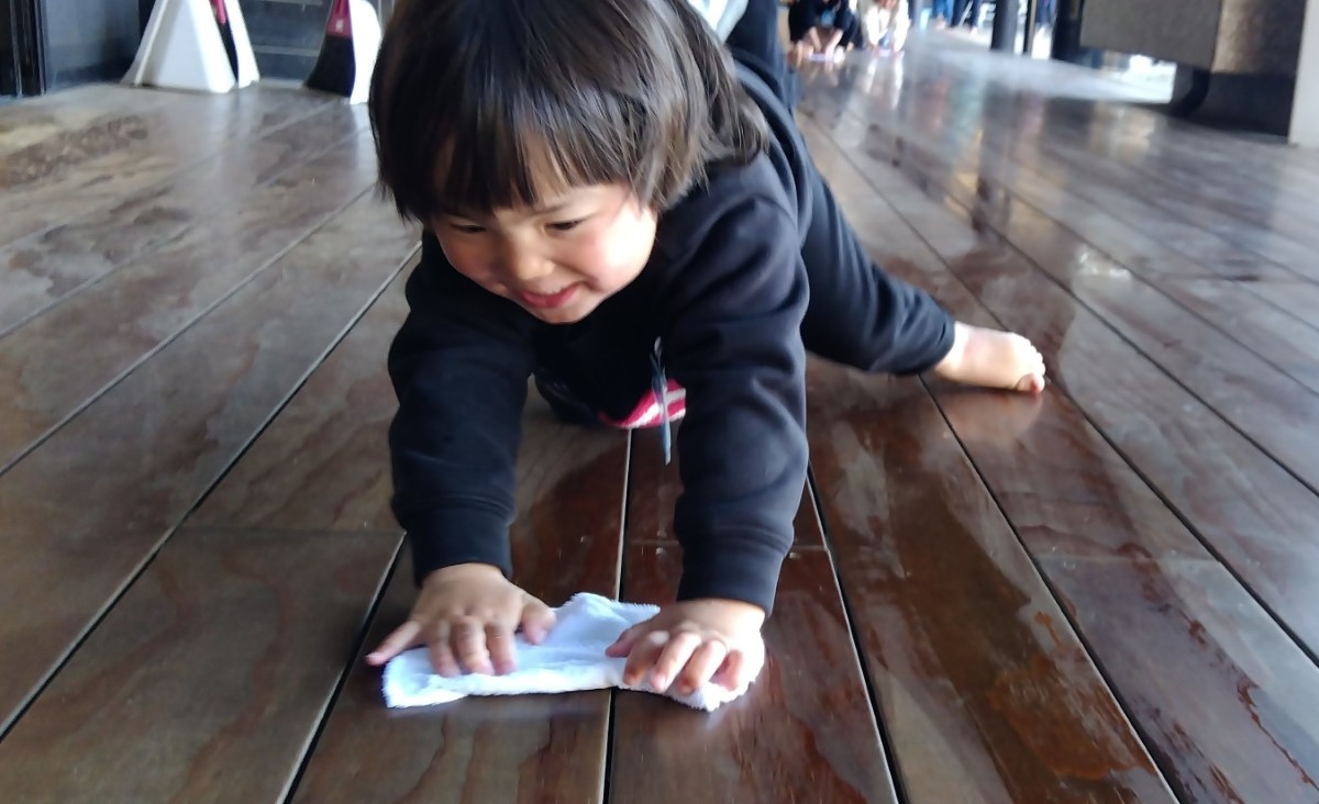 子どもが縁側を雑巾がけをしている