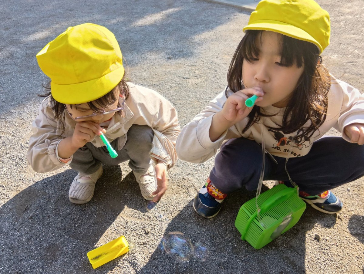 二人の子どもが並んでシャボン玉を吹いている。