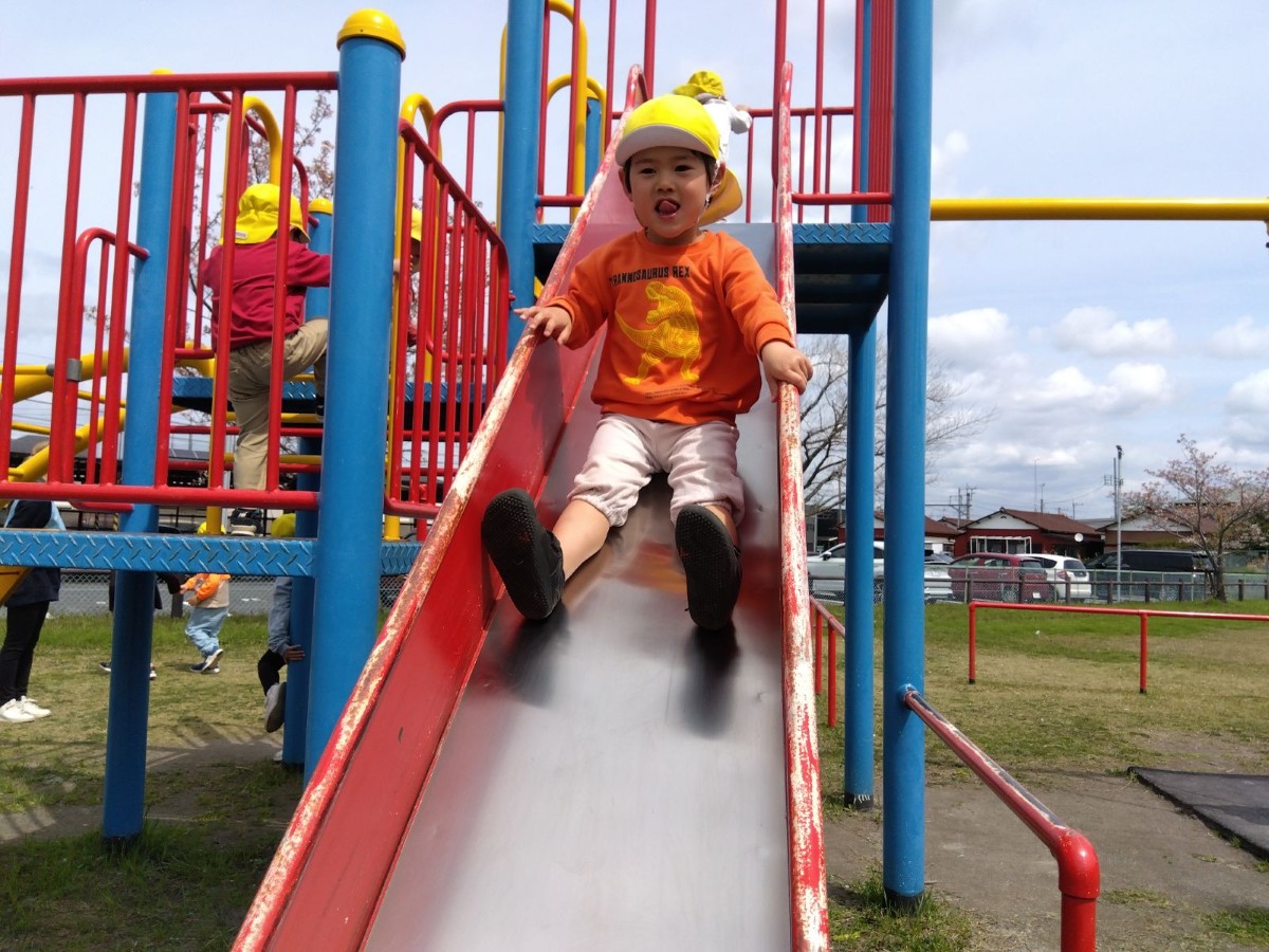 子どもたちは大型遊具で思い思いに遊び、階段を上る子、滑り台を滑り降りる子などがいる。