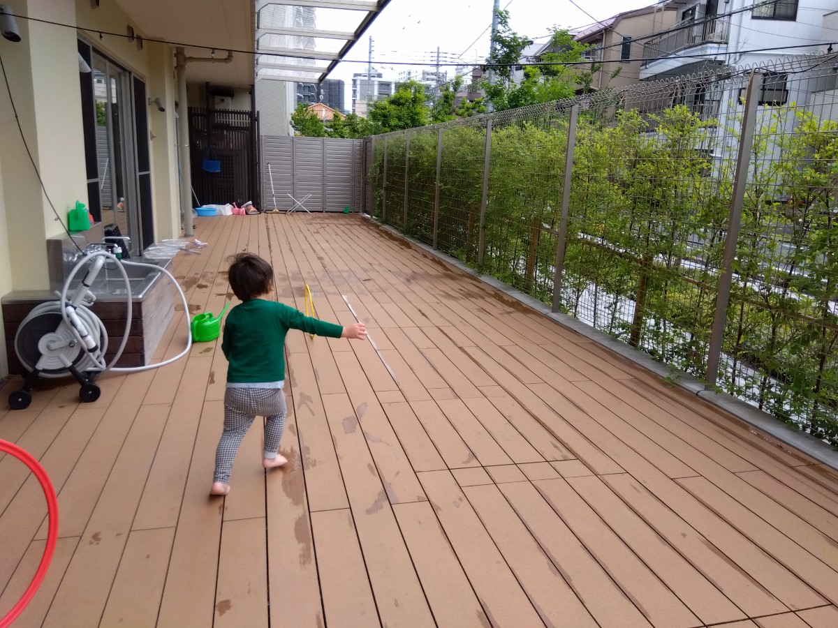 テラスで子どもがフープを追いかけている。