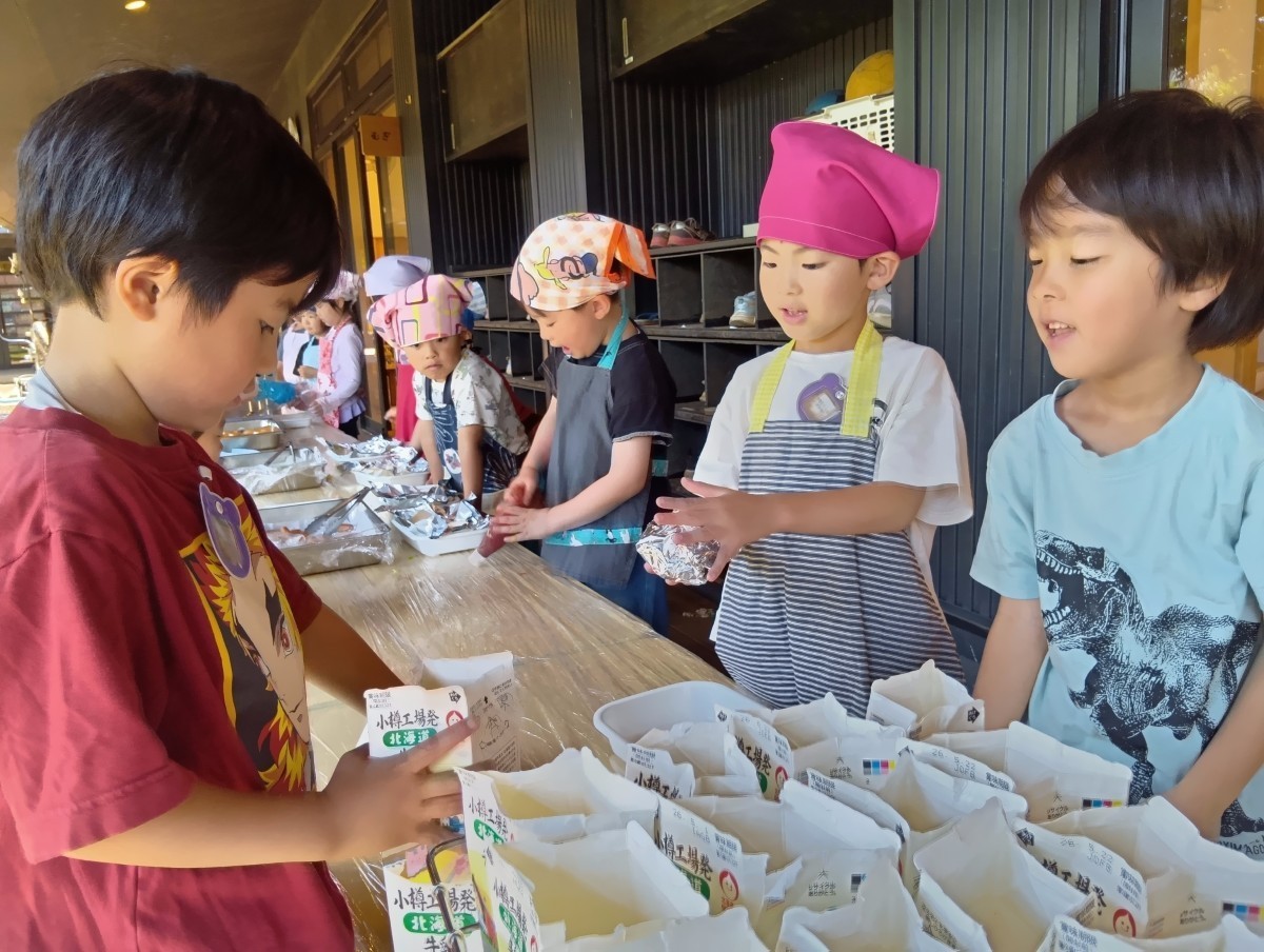 ケチャップをかけている子どもたちの隣では、牛乳パックを並べている子どもたちがいる。