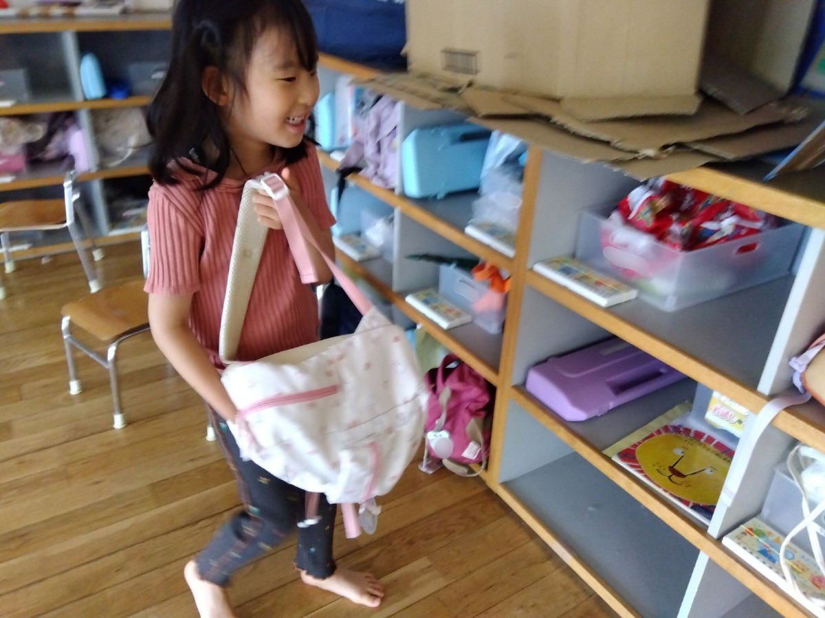 一人の子どもがロッカーにカバンを入れようとしている。