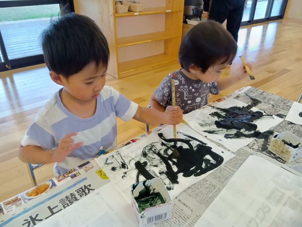 筆を握った子どもたちは、半紙の上で思い思いに筆を動かし、墨の跡をよく見ている