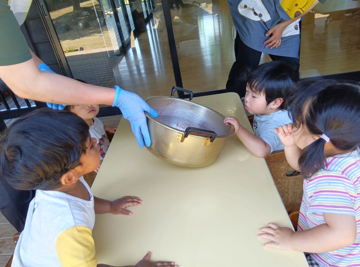 子どもたちはつぶれたイチゴが入った大きな鍋を覗き込んでいる