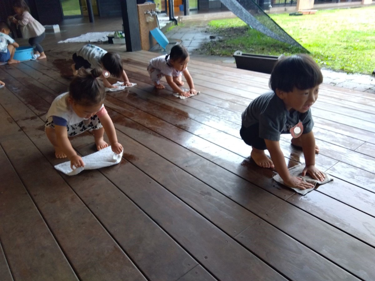 子どもたちが膝を曲げながら雑巾がけをしている