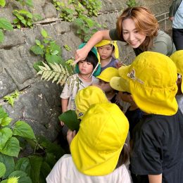 散歩先で子どもたちと葉を眺める小川施設長
