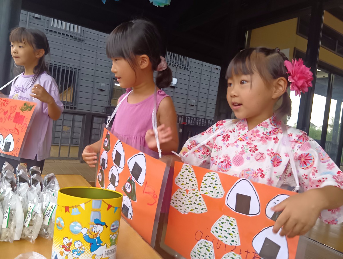 「おにぎり」のブースでは、おにぎりの挿絵の看板を首から掛けた子どもたちが声を出している