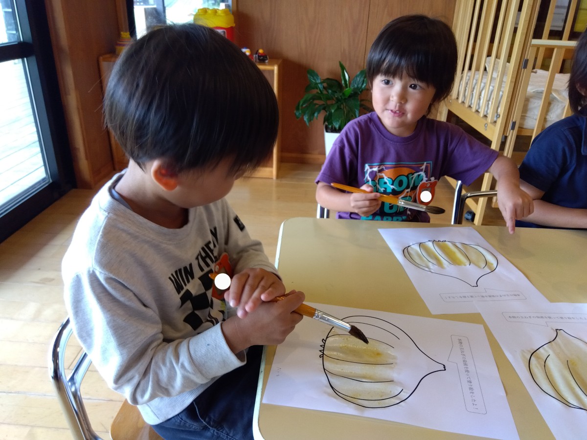 塗り絵コーナーで、子どもたちが玉ねぎの塗り絵を染液で塗っている