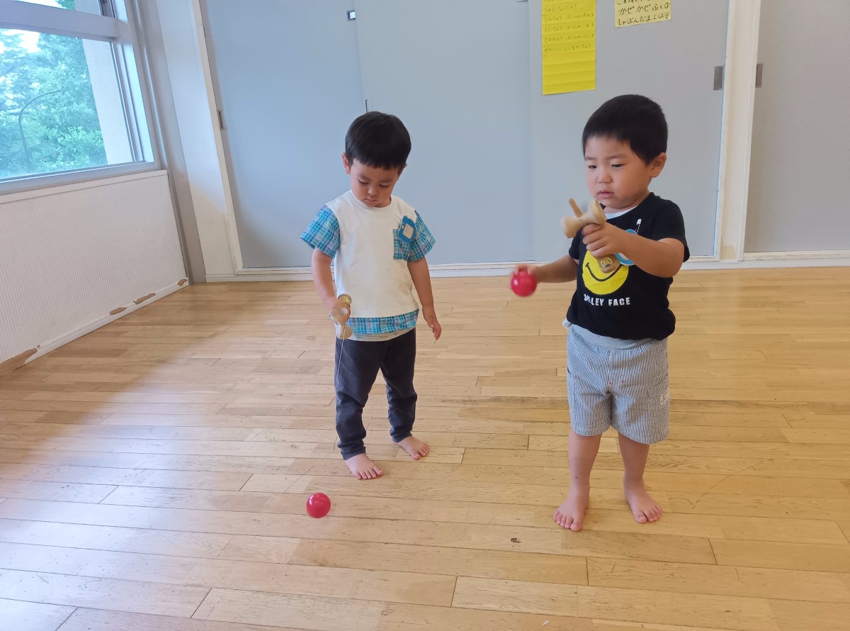 二人の子どもがけん玉に挑戦している