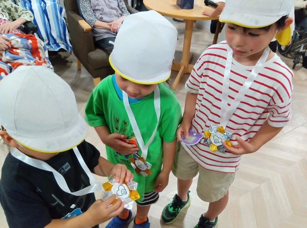 子どもたちは首にかけたメダルを友達同士で見せあっている