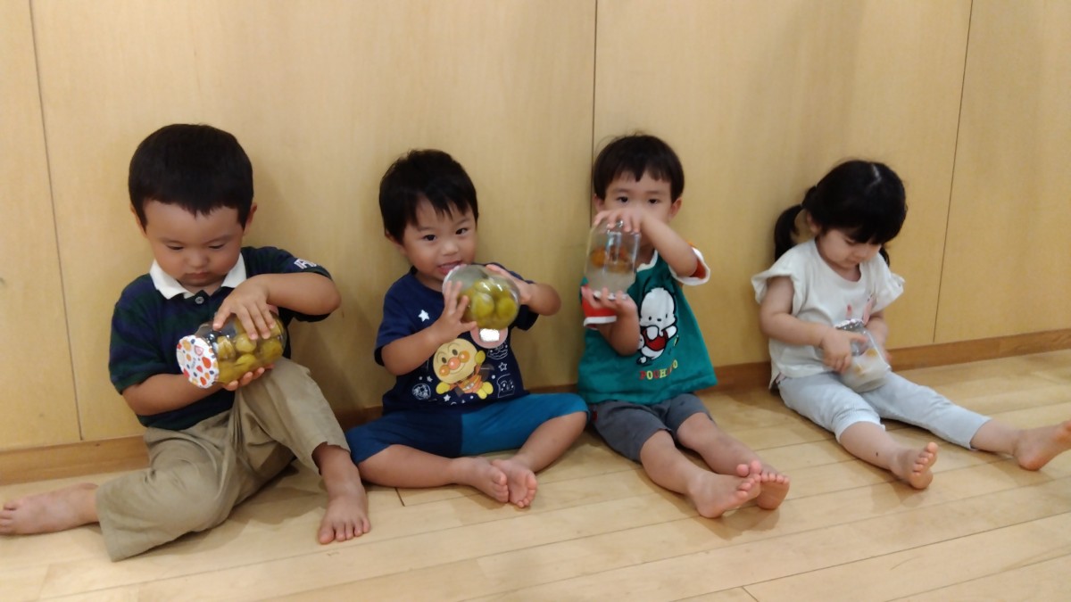 子どもたちは梅の入った瓶を笑顔で振っている