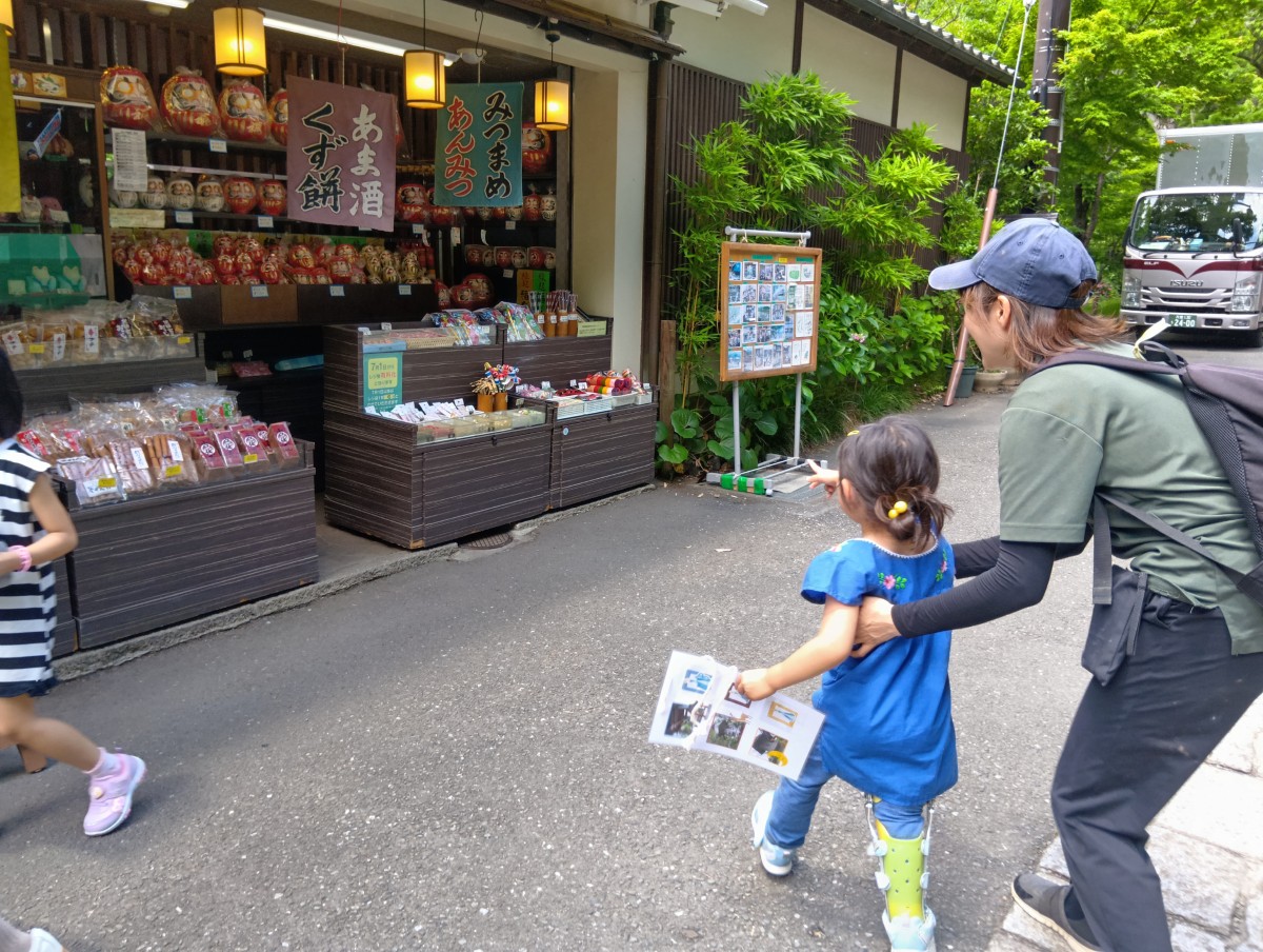 一人の子どもが商店の品物を指さして店に近づこうとしている