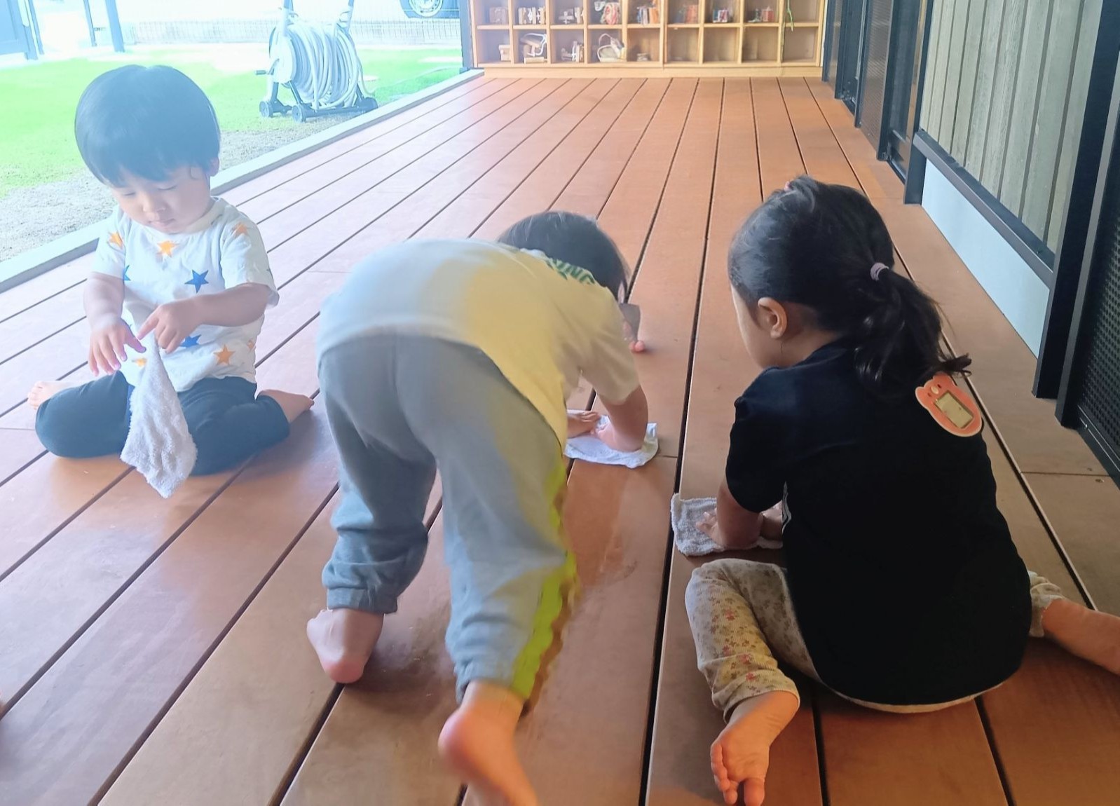 子どもたちは縁側で膝をつきながら雑巾がけをしている