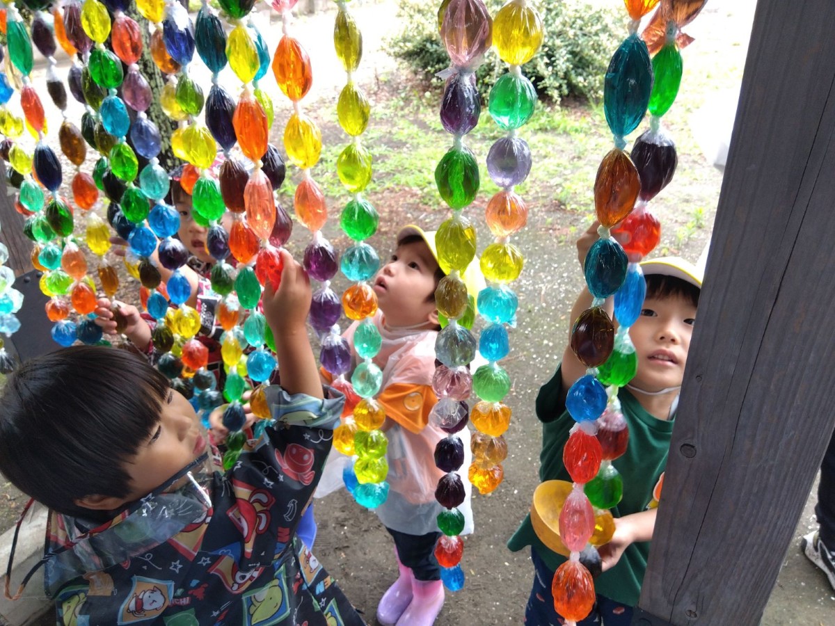 子どもたちは軒にぶら下がっている水彩のれんを見上げ、手を伸ばして触っている